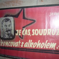 Plakát z muzea komunismu v 1. patře stodoly